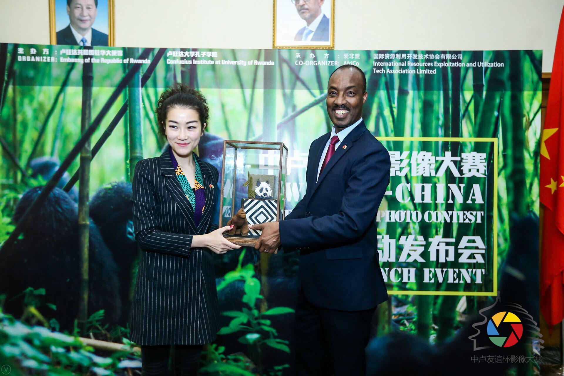 盧旺達共和國駐中國大使查爾斯&bull;卡勇加閣下（右）向&ldquo;中盧友誼杯&rdquo;影像大賽承辦方愛非盟(AfriCo)創始人李青女士（左）互贈禮物