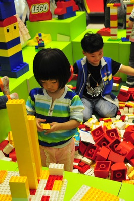 小朋友沉浸在樂高積木的世界里，專心致志地拼搭自己的作品。